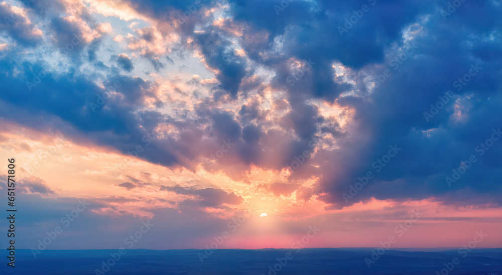 Aerial, long panoramic view of colorful, orange and blue colored streakes of   clouds on deep blue evening sky.  Ideal for sky replacement projects, no obstacles in the front. 