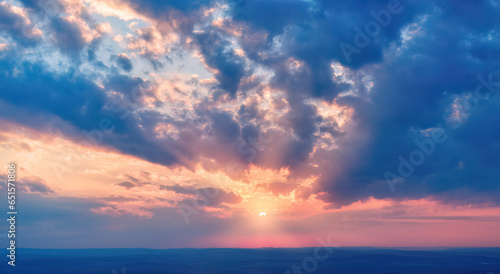 Aerial, long panoramic view of colorful, orange and blue colored streakes of clouds on deep blue evening sky. Ideal for sky replacement projects, no obstacles in the front. 