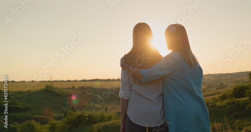Canvastavla Mom hugs her teenage daughter, watching the sunset over a picturesque valley