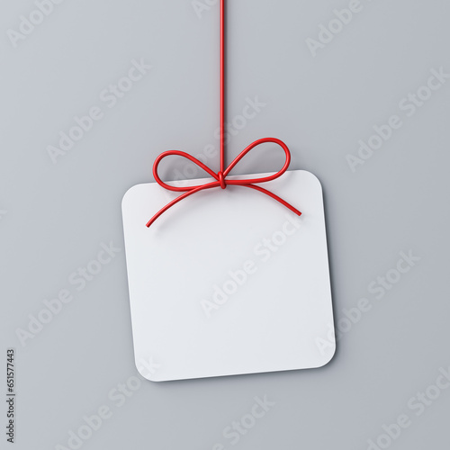 Hanging minimal gift box rounded square sign paper card with red ribbon rope bow isolated on grey background with shadow minimal conceptual 3D rendering