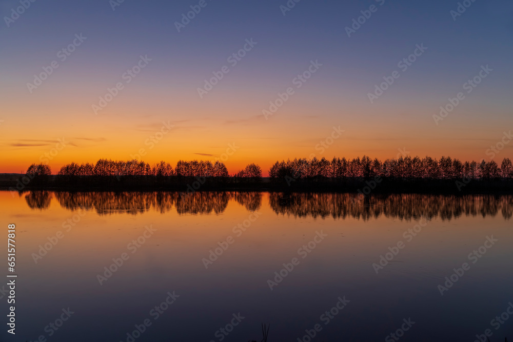 beautiful orange-yellow sunset on the lake in spring beautiful orange-yellow sunset on the lake in spring