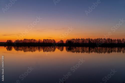 beautiful orange-yellow sunset on the lake in spring