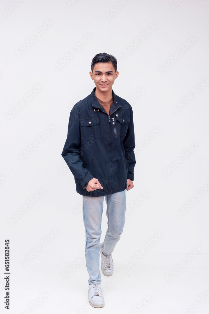A young filipino man walking forward and looking upbeat. Active dynamic teenager in motion. Isolated on a white backdrop. A young filipino man walking forward and looking upbeat. Active dynamic teenager in motion. Isolated on a white backdrop.