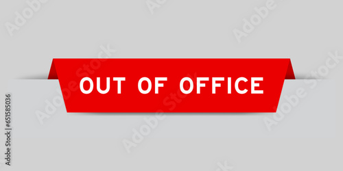 Red color inserted label with word out of office on gray background