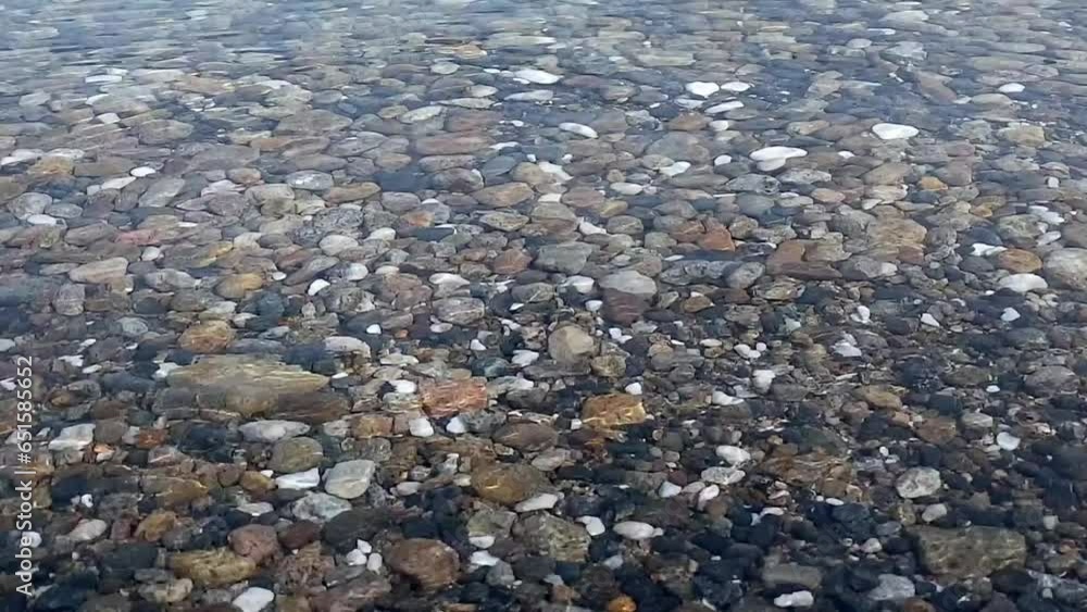 pebbles on the beach. water ripples over a rocky bottom. pebble beach. clear clear water on lake baikal pebbles on the beach. water ripples over a rocky bottom. pebble beach. clear clear water on lake baikal