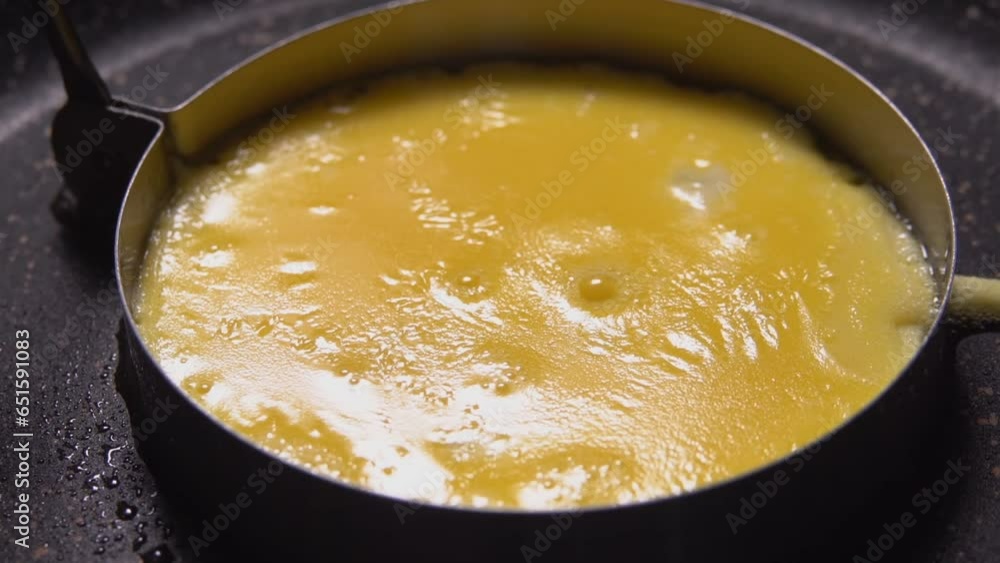Super close-up of an egg yolk fried in mold in a frying pan Super close-up of an egg yolk fried in mold in a frying pan