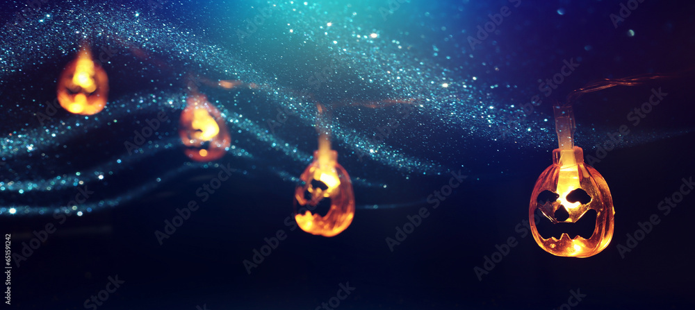 Fototapeta premium holidays concept of Halloween. Glitter background with colorful garland lights