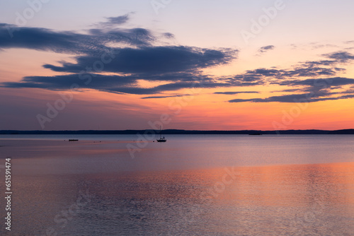Tiny sailboat anchored in Frenchman Bay during a pink and orange sunrise  Bar Harbor  Maine  USA 