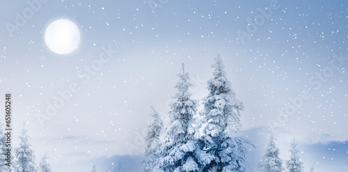 Unscharfer Winterhintergrund mit Tannenbäume im Winter bei Schneefall