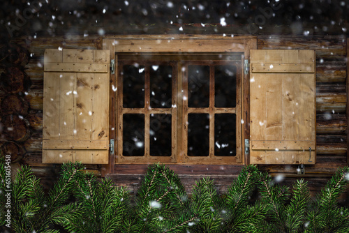 Holzfenster mit Tannenzweigen als Dekoration und Schneeflocken