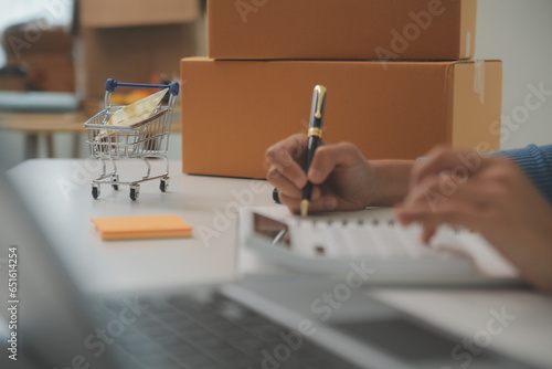 Business woman start up small business entrepreneur SME success .freelance woman working at home with Online Parcel delivery. SME and packaging deliveryconcept photo