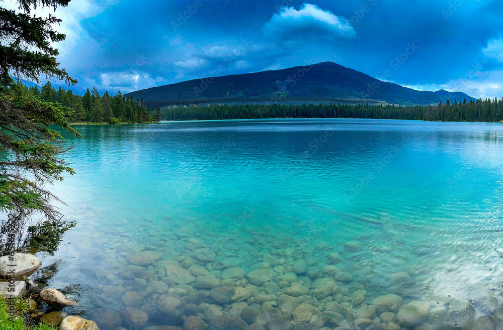 Blue green lake water with mountain backdrop