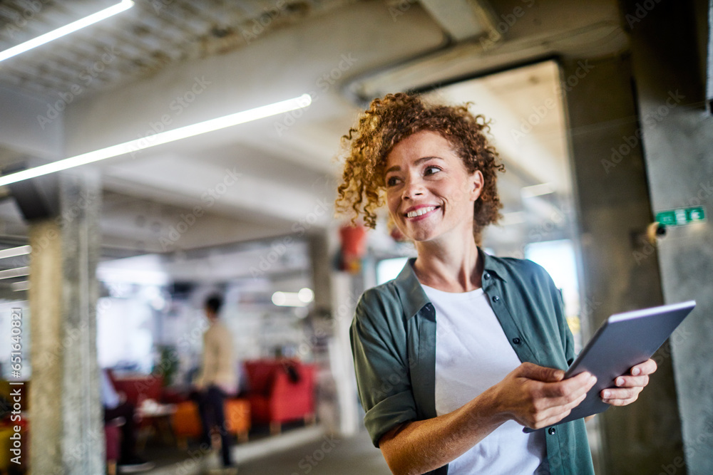 Young Caucasian woman using a tablet in the office of a startup company Young Caucasian woman using a tablet in the office of a startup company