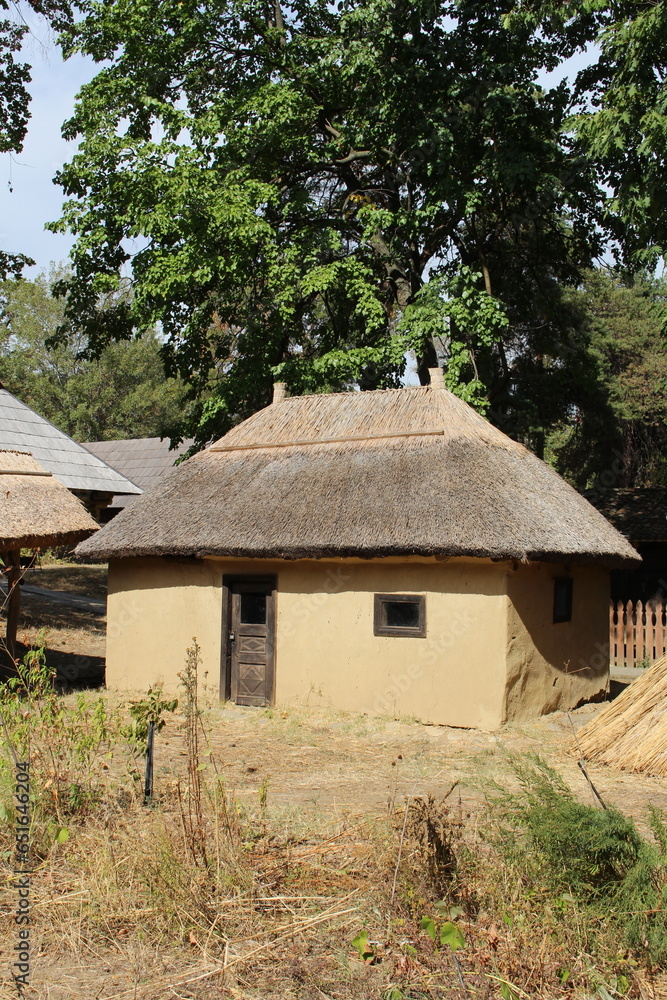 A house with a dirt path and trees in the background