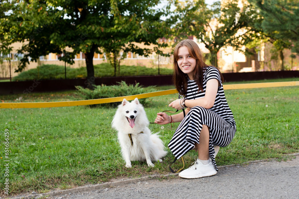 A young teenage girl is walking her beloved dog, they walked and ran together a lot in city, in the park and now sat down to rest and catch their breath, both are happy A young teenage girl is walking her beloved dog, they walked and ran together a lot in city, in the park and now sat down to rest and catch their breath, both are happy
