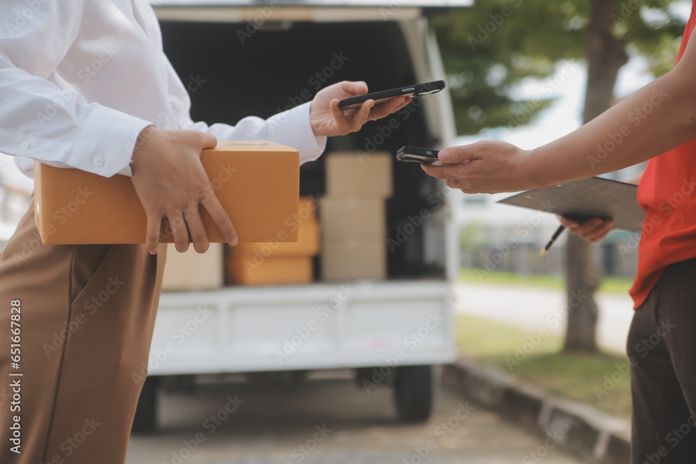 Obraz premium Asian Woman Receiving Product from delivery man at Home, Young Owner Woman Order Product from Smartphone Application, Woman with Online Business or SME Concept.