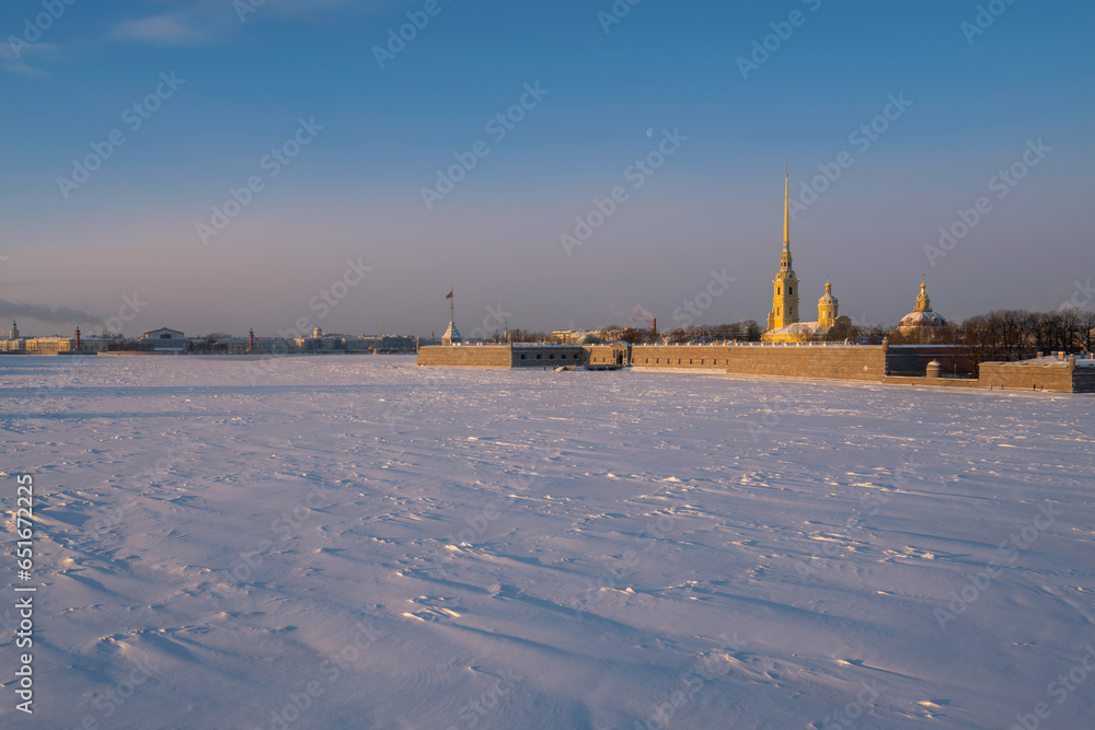 View of the Peter and Paul Fortress and Vasilievsky Island from the Trinity Bridge over the Neva River on a sunny winter morning with clouds, St. Petersburg, Russia