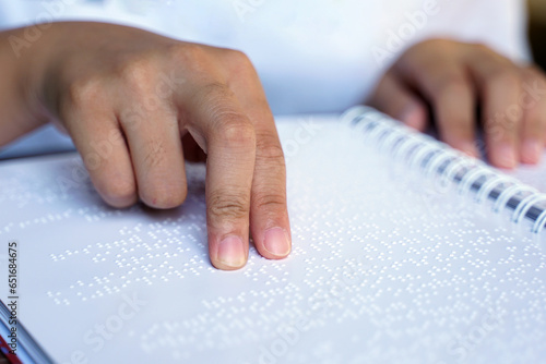 Fotografi Visually impaired person reads with his fingers a book written in braille It is written for those who are visually impaired or blind