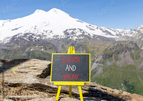 Learn and grow symbol. Concept word Learn And Grow on beautiful black chalk blackboard. Beautiful mountain Elbrus blue sky background. Business, education learn and grow concept. Copy space. © Dzmitry