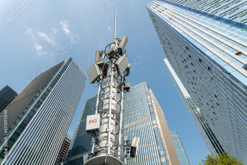 low angle view of 5g transmitter tower and modern office buildings. photo