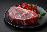 Fresh raw beef striploin steak with salt, spices and herbs