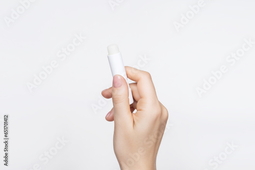female hand holding hygienic lip balm on a white background