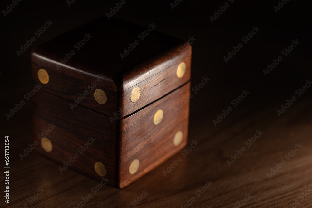 Dice, a wooden dice-shaped case for storing small dice, selective focus. Dice, a wooden dice-shaped case for storing small dice, selective focus.