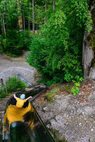 young boy on the slide in the forest playground