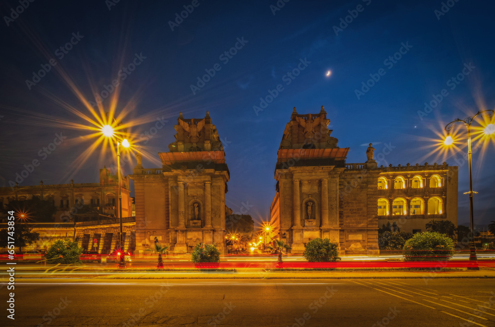 Monumental city gate Porta Felice in Palermo, water-side entrance of the main and most ancient street of Palermo, Sicily. Night view with headlight tracks. Long exposure picture. June 2023