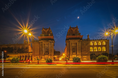Monumental city gate Porta Felice in Palermo, water-side entrance of the main and most ancient street of Palermo, Sicily. Night view with headlight tracks. Long exposure picture. June 2023