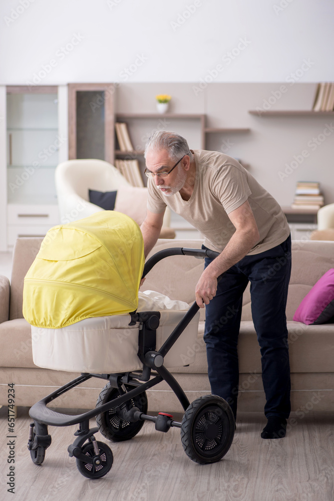 Old man looking after newborn at home Old man looking after newborn at home