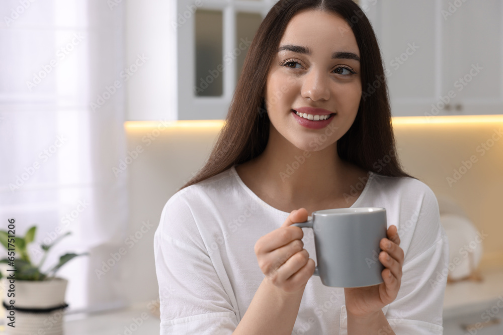 Happy woman with cup of drink in kitchen, space for text. Lazy morning Happy woman with cup of drink in kitchen, space for text. Lazy morning