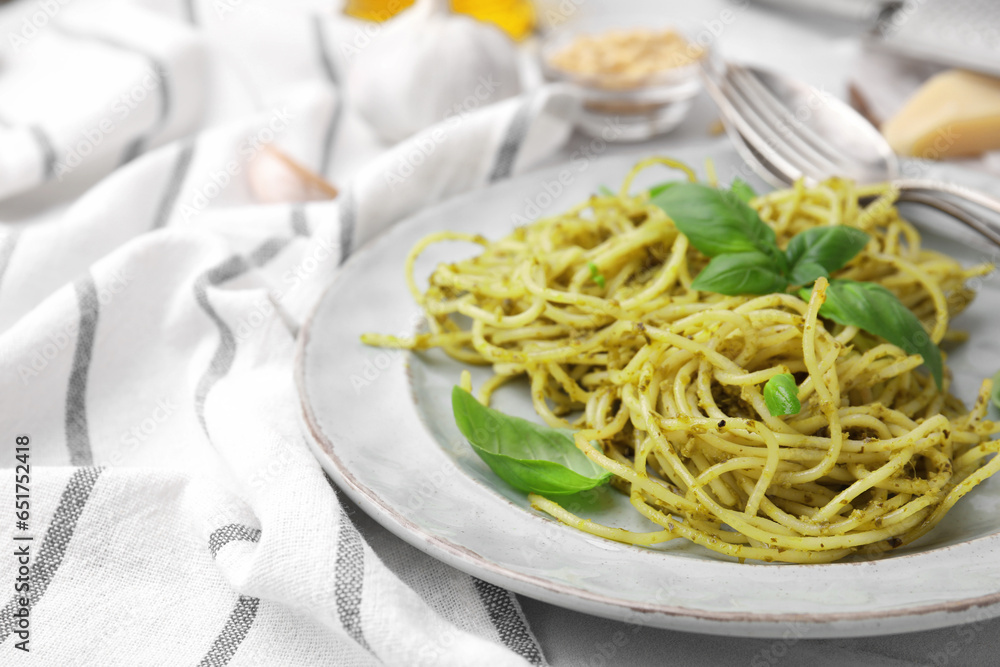 Delicious pasta with pesto sauce and basil on table, closeup. Space for text
