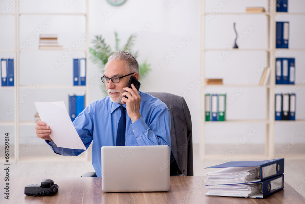 Old male employee working in the office Old male employee working in the office