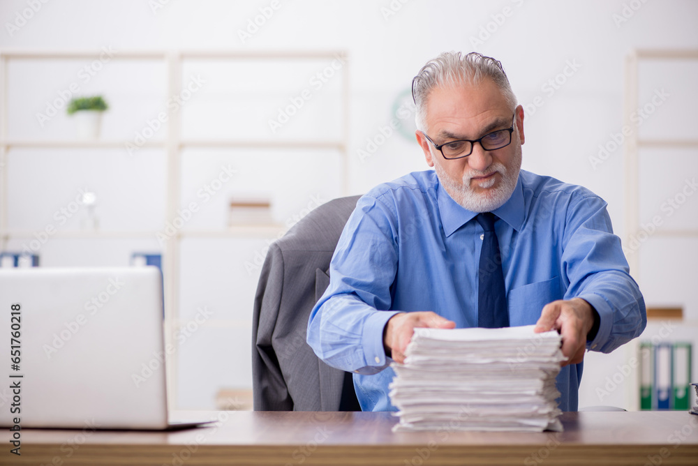 Old male employee working in the office Old male employee working in the office