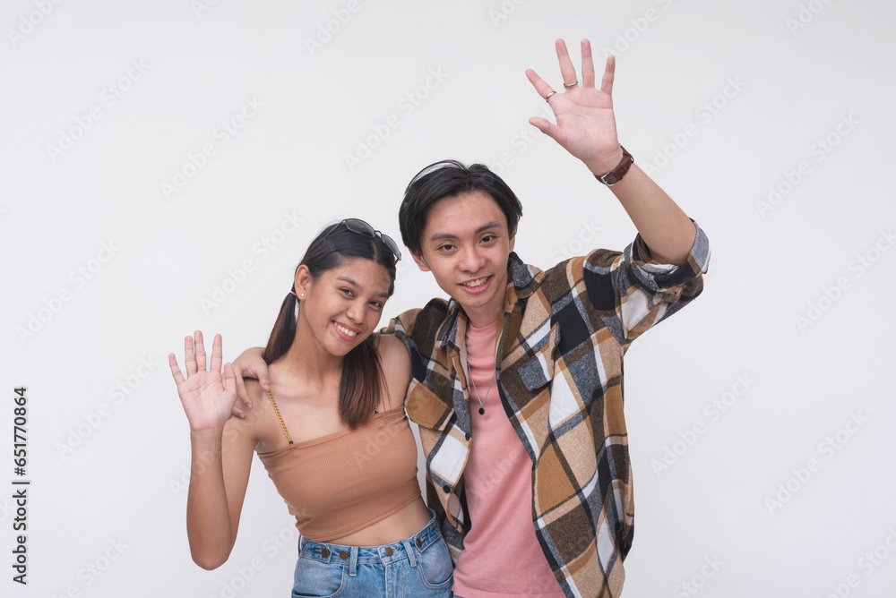 Friendly international freshman college students saying hi. One Filipina lady and one chinese guy. Isolated on a white backdrop. Friendly international freshman college students saying hi. One Filipina lady and one chinese guy. Isolated on a white backdrop.