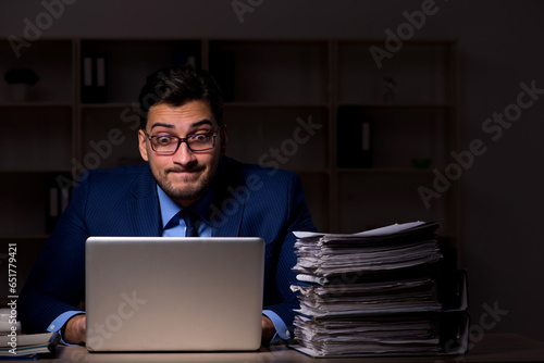 Young male employee working late in the office