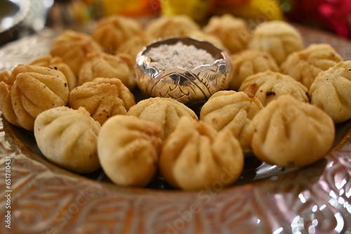 Beautiful Plate with the fresh fried Modak. Sweets for Lord Ganesha. Silver Bowl with coconut and sugar. Prasad for Lord Ganesha. Chaturthi festival Chaturdashi festival Visarjan Pooja. Diwali modak