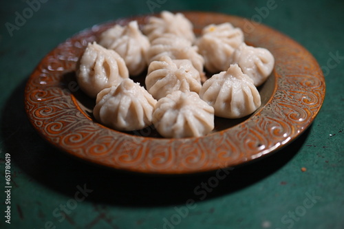 Plate with steamed Modak. Favorite sweets of the Lord Ganesha. Modak steamed with rice flour, jaggery, coconut. Chaturthi, Chaturdashi, Visarjan of lord Ganesha.  photo