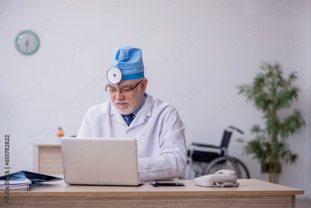 Old male docror otolaryngologist working in the clinic Old male docror otolaryngologist working in the clinic