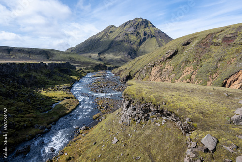 River amidst volcanic landscape of Fjallabak Nature Reserve in Icelandic highlands on sunny autumn afternoon..