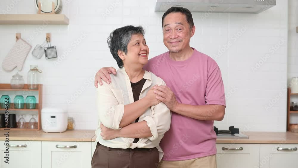 Loving happy Asian senior couple hugging in her modern kitchen at home Loving happy Asian senior couple hugging in her modern kitchen at home