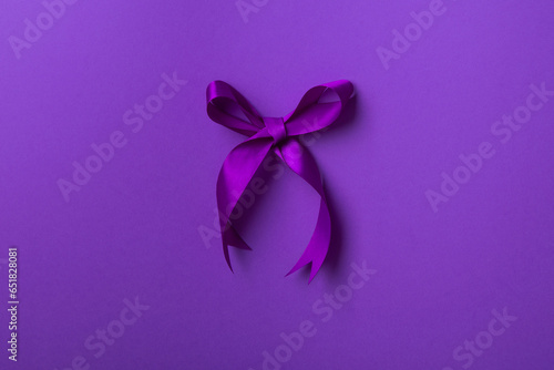 Purple bow ribbon isolated on purple background.