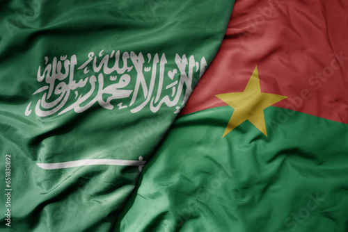 big waving realistic national colorful flag of saudi arabia and national flag of burkina faso .