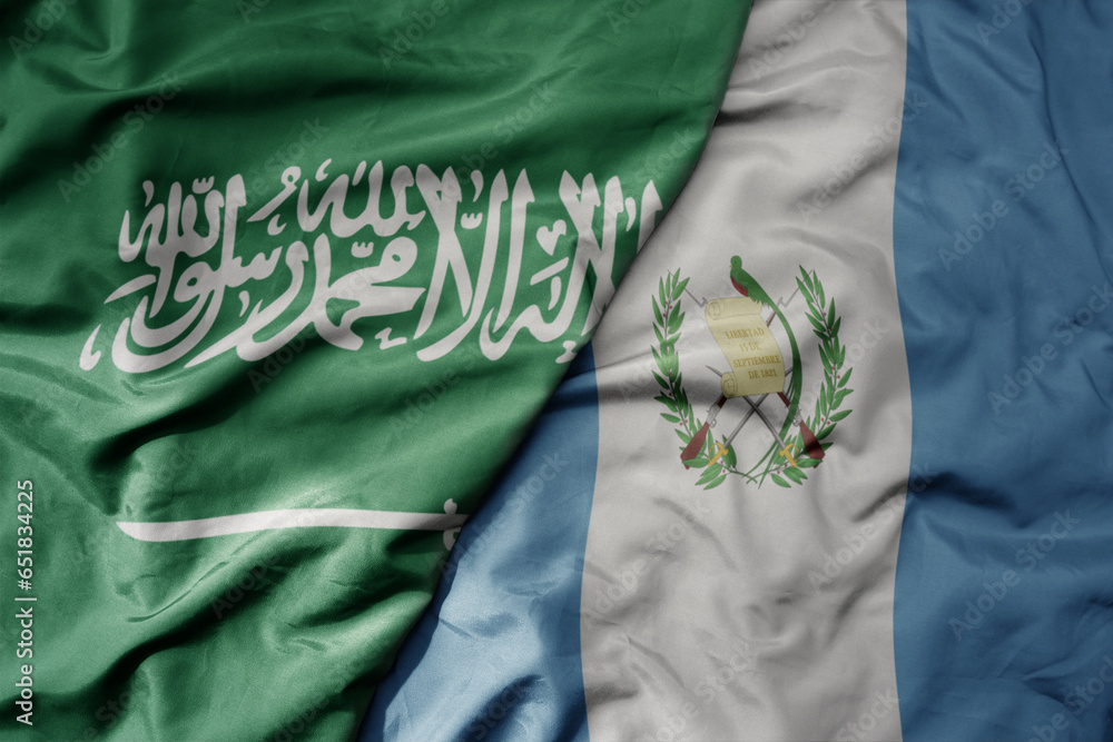 big waving realistic national colorful flag of saudi arabia and national flag of guatemala .