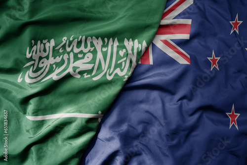 big waving realistic national colorful flag of saudi arabia and national flag of new zealand .