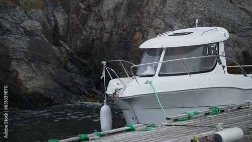 Small motor boat at anchor by rope in Replot pier. lofoten Norway photo