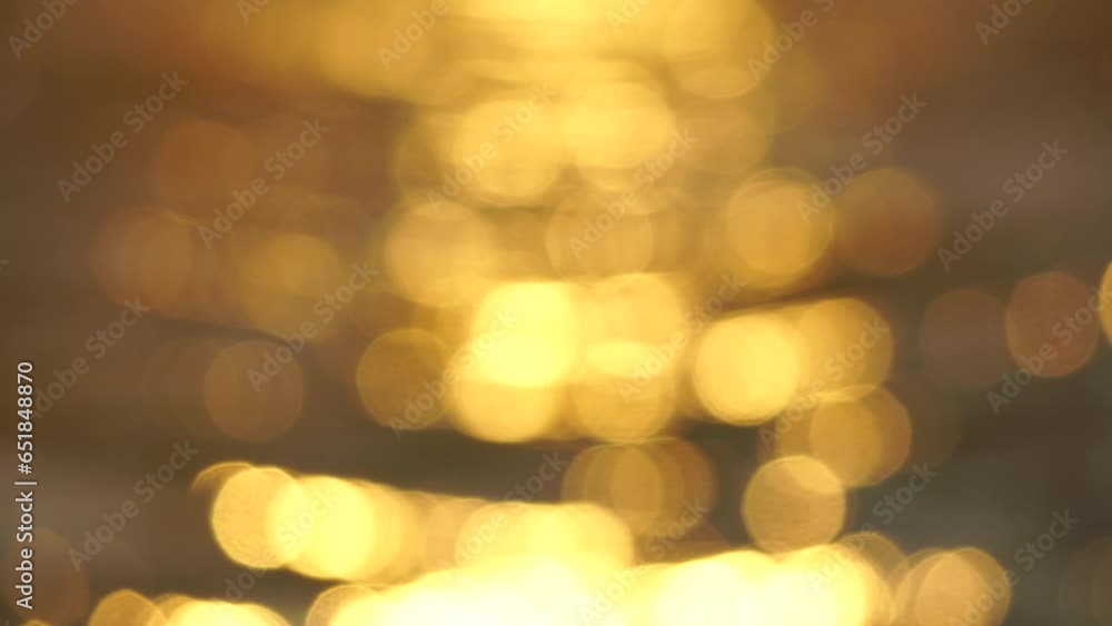 Blurred golden sea at sunset. The sun reflects and sparkles on the waves with bokeh, illuminating the golden sea. Holiday recreation concept. Abstract nautical summer ocean sunset nature background. Blurred golden sea at sunset. The sun reflects and sparkles on the waves with bokeh, illuminating the golden sea. Holiday recreation concept. Abstract nautical summer ocean sunset nature background.