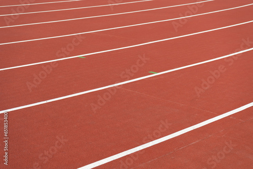 Running track surface with lanes and lines on a track and field athletics stadium. Sport running, jogging or walking runway.