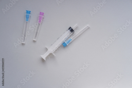 medical syringe with needles on a gray background.